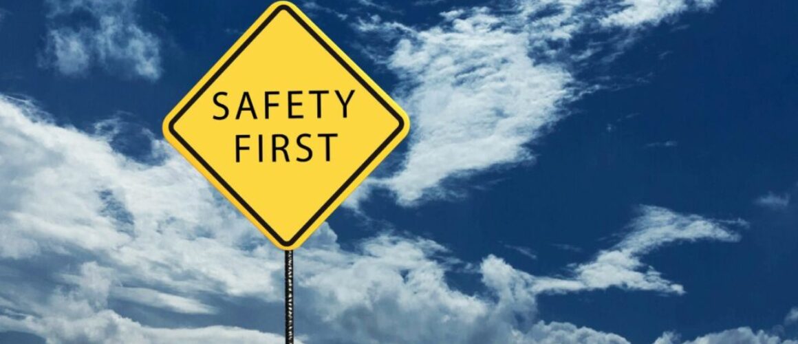 safety first on a yellow signpost with the blue skies on the background