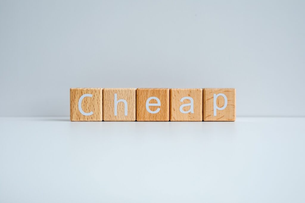 Wooden blocks form the text Cheap against a white background