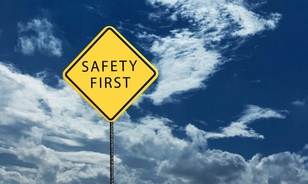 words safety first painted on a yellow street sign