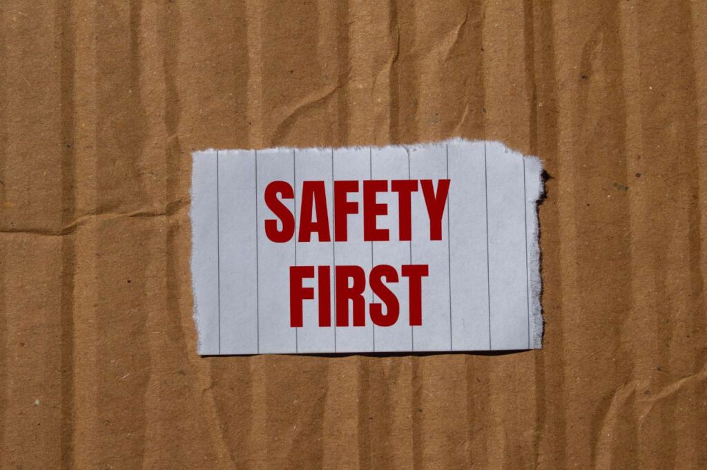
Safety first message written on ripped torn paper with cardboard background