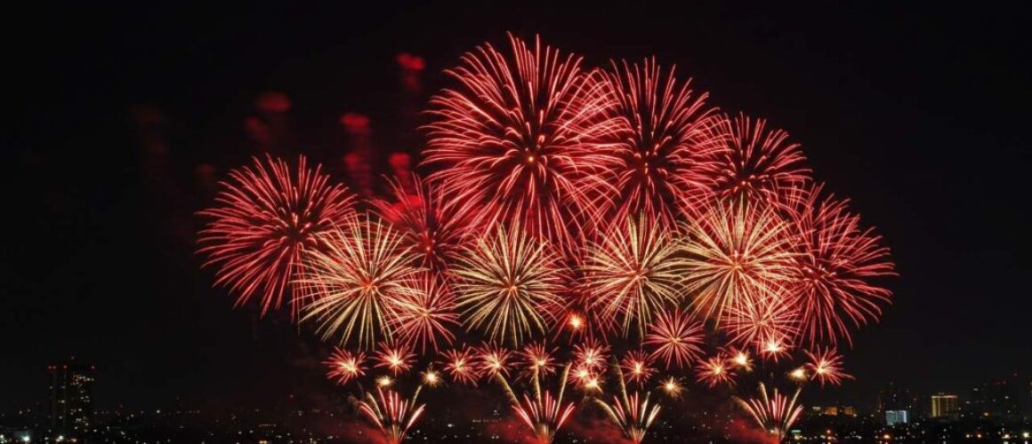 Fireworks display over city skyline illuminating night sky for celebration