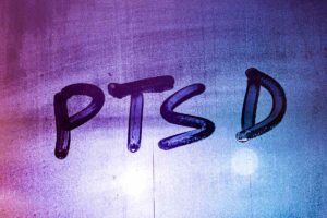 abbreviation ptsd handwritten on night wet window glass