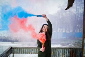 girl with blue and red colored smoke bomb
