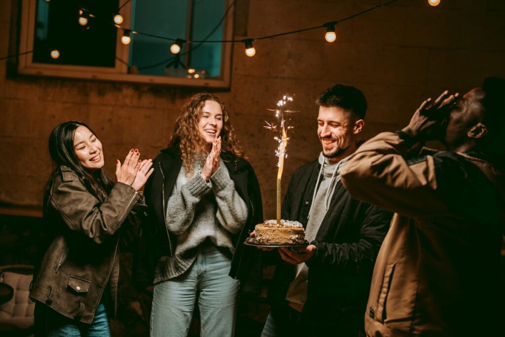 Celebration with friends and a sparkling cake during nighttime gathering in cozy atmosphere
