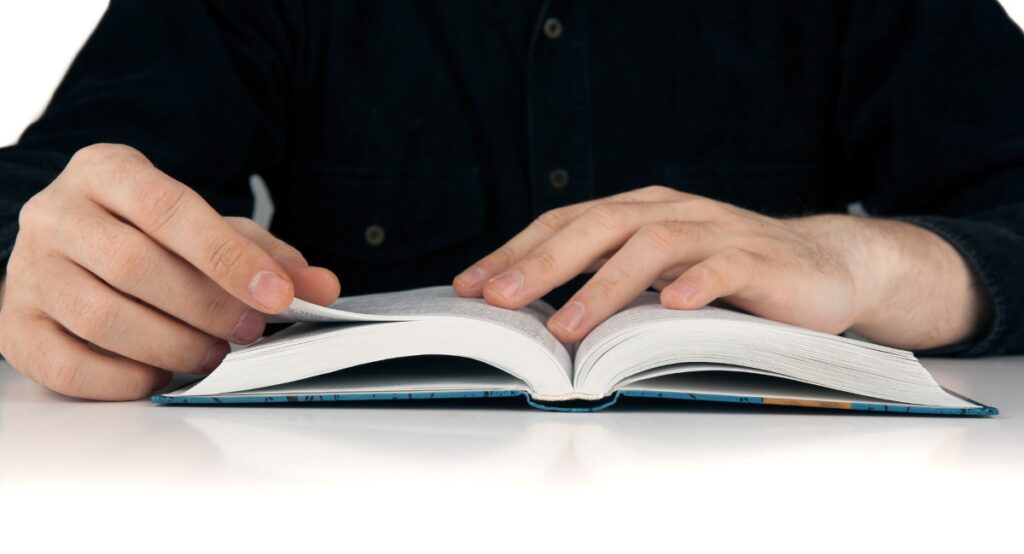 person's hands holding a dictionary