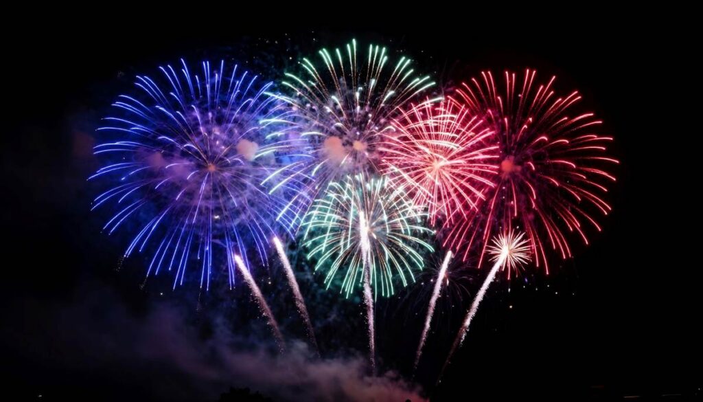 Spectacular fireworks display in vibrant red, green, and blue illuminating the night sky