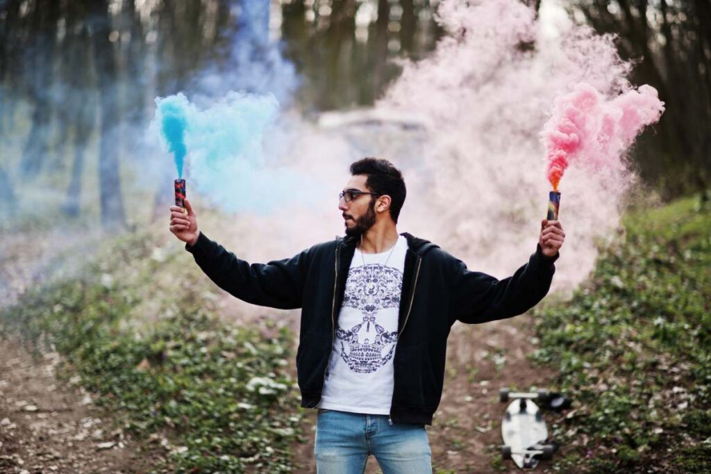Street style arab man in eyeglasses hold hand flare with red and blue smoke grenade bomb